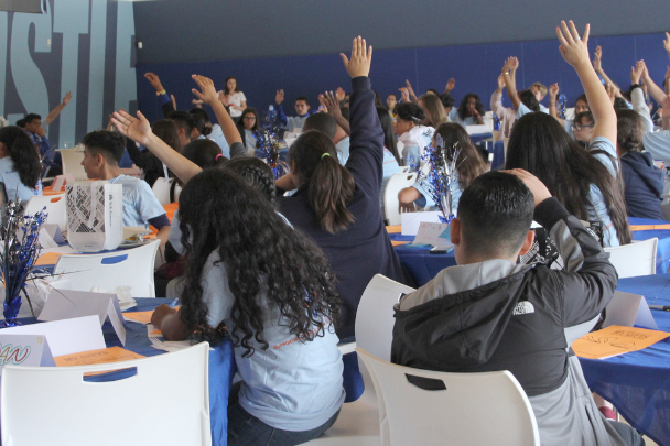 Kids with hands raised at leadership academy